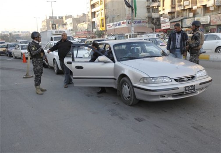 Iraqi security forces search people and cars while hundreds of vehicles are in queue, waiting to be searched, at a checkpoint in Baghdad, Iraq, on Tuesday, Dec. 28. Security officials are investigating the possibility of removing some of the hundreds of checkpoints across the city, in a sign of the improving security situation. The checkpoints are designed to catch insurgents, but they also slow down traffic in the already congested city. 